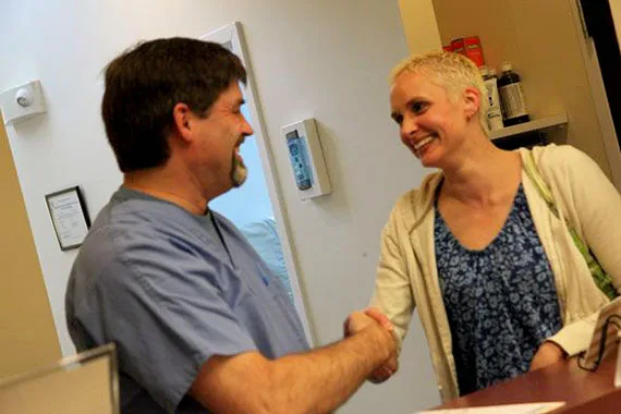 Dentist greeting a patient with a handshake