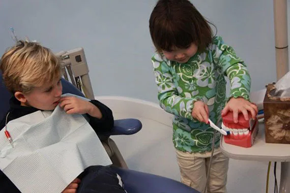 Children learning to brush with a dental model