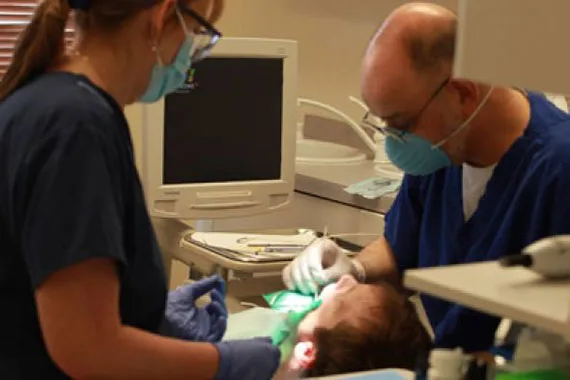 Dentist and assistant treating a patient